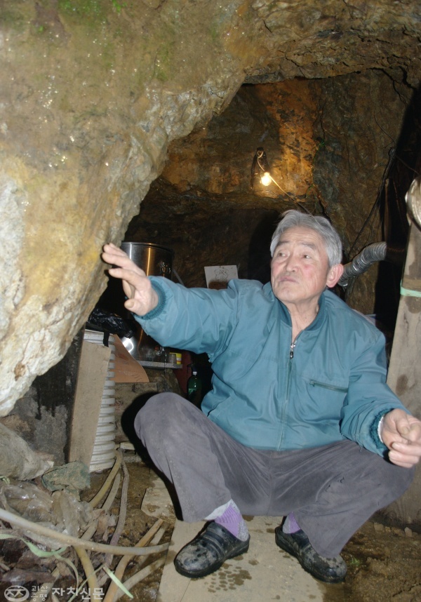 신도식 할아버지가 자신이 판 동굴 입구에서 동굴 파기에 대해 설명하고 있다.