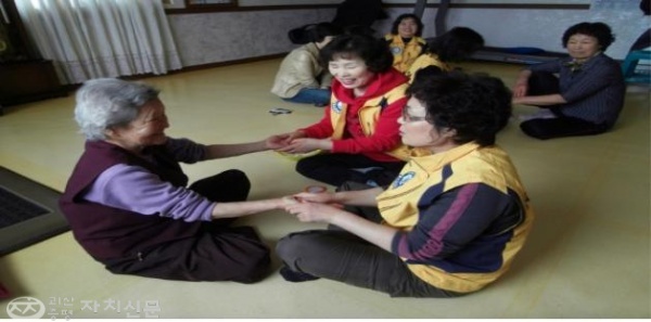 회원들이 증평읍 미암리 4구 경노당에서 어르신들에게 손 마사지를 해드리고 있다.