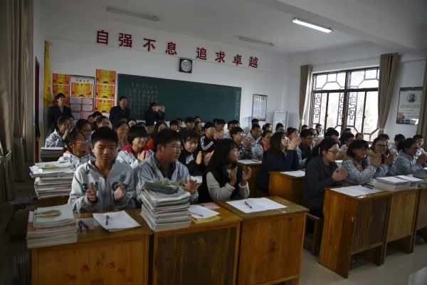 청소년교류단이 관남현 고급중학교를 방문해 중국학생들(체육복을 입은 학생들)과 함께 영어수업을 하고 있다.