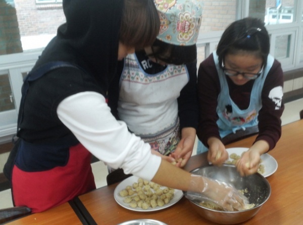 괴산명덕초 6학년 학생들이 흑미땅콩단자를 만들기 위해 볶은 땅콩 분태를 이용해 단자에 넣을 소를 만들고 있다.