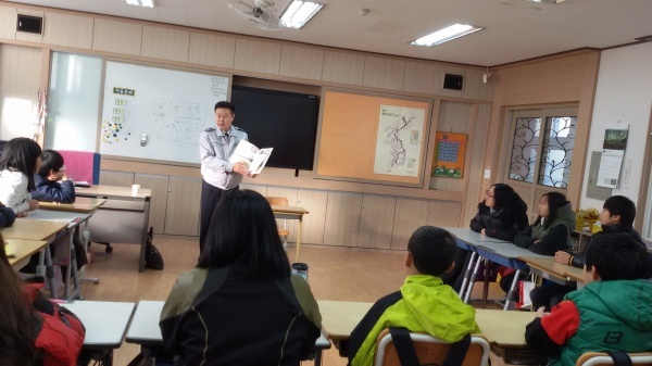 김주완 연풍지구대장이 연풍초 6학년 학생들에게 그림책을 읽어주고 있다.