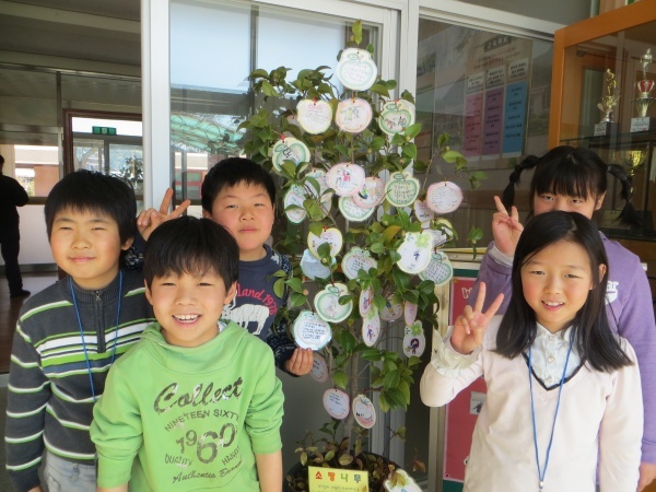 ▲ 송면초 어린이들이 소망나무에 꿈과 소망을 기록한 쪽지가 달고 기념 촬영을 하고 있다.  