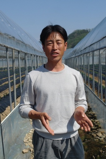 ▲ 김동수 씨가 비닐하우스를 배경으로 고품질 농산물 생산에 대해 이야기하고 있다. 