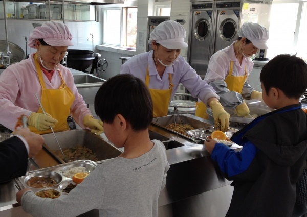 ▲ 노인들이 초등학교 급식소에서 배식을 하고 있다. 